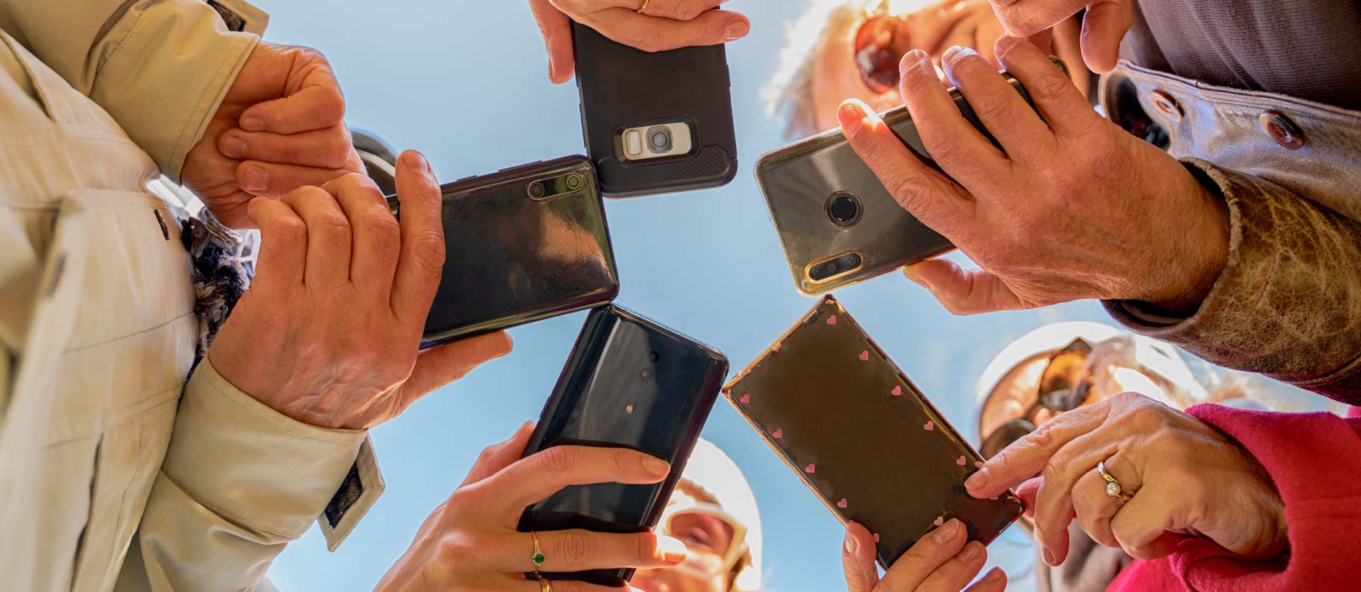 Group of all ages holding and using smartphones.